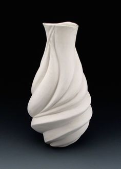 a white vase sitting on top of a table