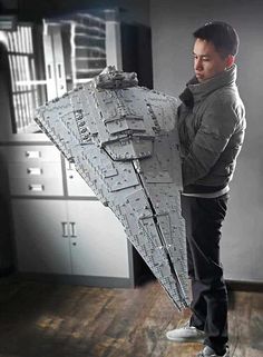 a man standing in front of a lego star destroyer