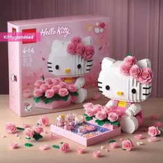 a hello kitty lego set with pink roses and flowers in front of the box, next to it's contents