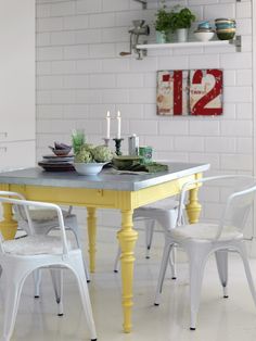 a yellow table with white chairs around it