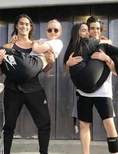 four people are posing for a photo with one person holding an inflatable ball