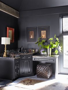 a kitchen with black walls and wooden floors