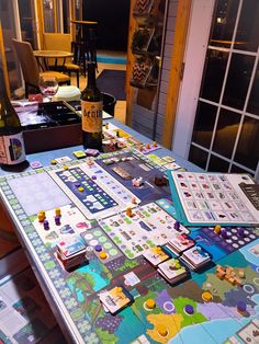 a table that has some wine bottles on it and several cards laid out on the table