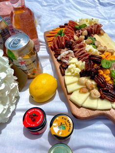 A charcuterie board with flowers on a white sheet on the beach Vintage Picnic, Charcuterie Board, Cheese Board, Camembert Cheese