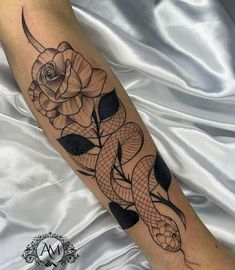 a snake and rose tattoo on the arm