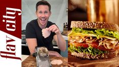 a man is holding up a sandwich with meat and vegetables on it while sitting at a table