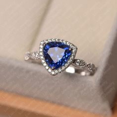 an engagement ring with a blue diamond in the center and white diamonds on the sides