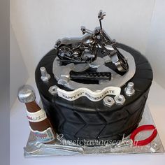 a motorcycle themed birthday cake with a bottle of booze on the table next to it