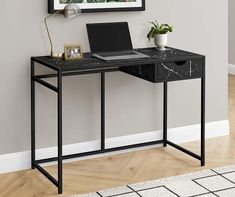 a black desk with a laptop on it