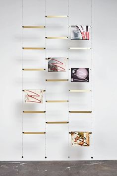 a white wall with some shelves and pictures on it