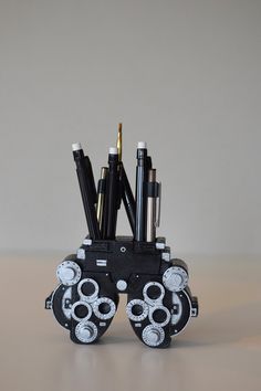 a pen holder with pens and pencils in it