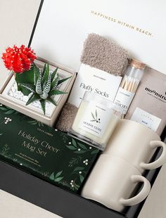 the holiday gift box contains two mugs, an assortment of skin care products and a towel