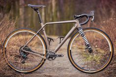 a bike parked on a dirt road in the woods