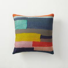 a multicolored pillow sitting on top of a white wall