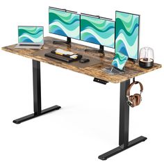 a computer desk with two monitors and headphones on it