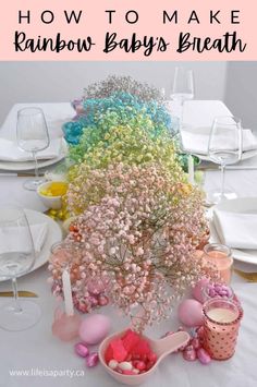 a rainbow baby's breath centerpiece on a table with white plates and napkins