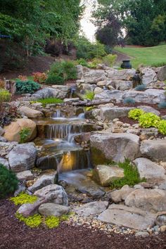 there is a small waterfall in the middle of this garden