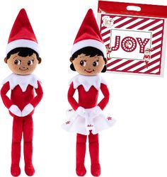 two elf dolls are standing next to each other in front of a red and white gift bag