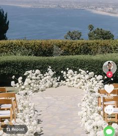 an outdoor ceremony setup with white flowers and greenery on the ground, surrounded by wooden chairs