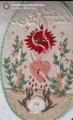 an embroidered heart with candles and flowers in the center is surrounded by other decorative items