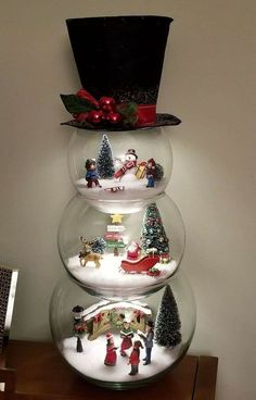 three snow globes with christmas decorations on them