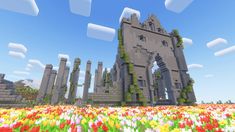 a large castle surrounded by lots of flowers in the middle of a field with blue sky and clouds