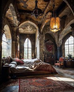 a large bed sitting in the middle of a room next to two arched windows and a chandelier