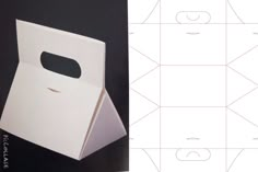 an open white box sitting on top of a black table next to a piece of paper