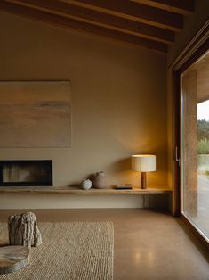 a living room with a large window and a painting on the wall next to it