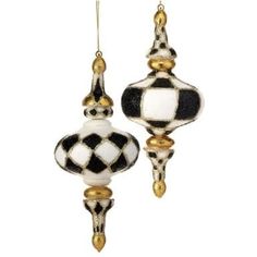 two black and white glass ornaments hanging from gold - plated hooks, one with an ornament on it