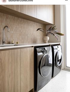 a washer and dryer in a kitchen next to a counter with a potted plant