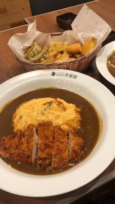 two plates of food on a table with bread and gravy in the middle