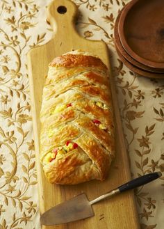 a loaf of bread sitting on top of a wooden cutting board next to a knife