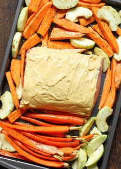 carrots, celery, and other vegetables in a baking pan with dip