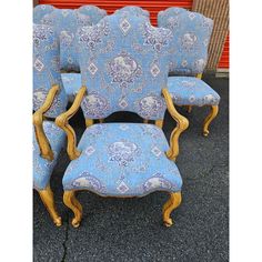 four blue chairs with gold trim on them