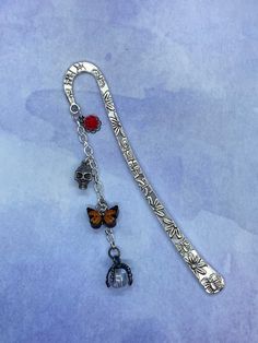 a long metal chain with charms attached to it on a blue background and watercolor paper