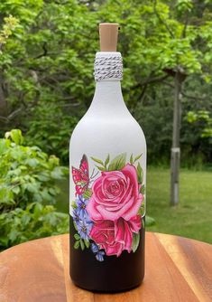 a painted bottle sitting on top of a wooden table