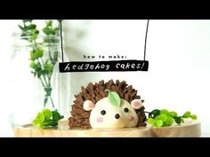 a hedgehog cake sitting on top of a wooden table next to a vase filled with flowers