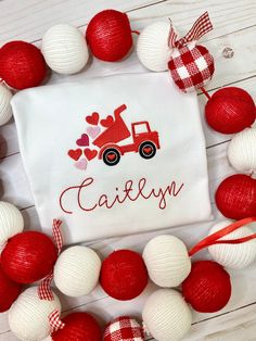 a red and white christmas ornament with a tractor on it, surrounded by balls