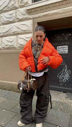 streetwear outfit inspo girl orange lfdy puffer jacket tehra cargo pants gold jewelry winter fashion woman louis vuitton vintage yeezy boots Collegiate Jacket Outfit, Teal And Orange Outfit, Cold Holiday Outfits, Orange Jacket Outfit Winter, Brown Outfit Streetwear, Orange Streetwear Outfit, Fashion Killa Winter, Orange Puffer Jacket Outfit, Fur Jacket Street Style