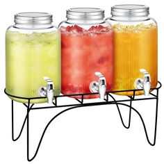 three different colored drinks in glass jars on a metal rack