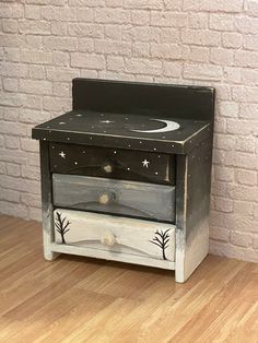 a night stand with two drawers on top of it and a brick wall in the background