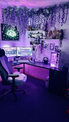 an office with purple lighting and lots of plants hanging from the ceiling over the desk