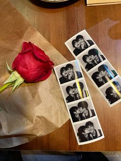 a rose and some polaroid pictures on a table