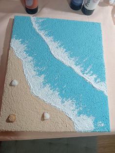 there is a cake made to look like an ocean beach with shells on the sand