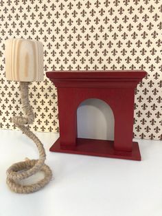 a wooden lamp with a rope attached to it next to a wallpapered background