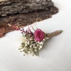 a bouquet of flowers sitting on top of a piece of wood next to a log