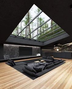 a large living room with wooden floors and skylights