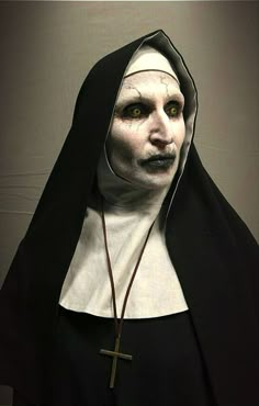 the nun is dressed in black and white with a cross on her chest, while she wears