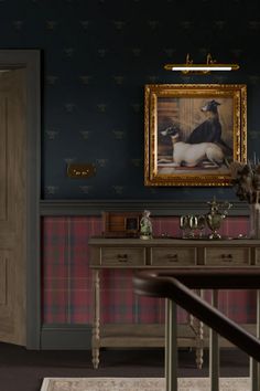 the room is decorated in blue and red plaid wallpaper, with a painting on the wall